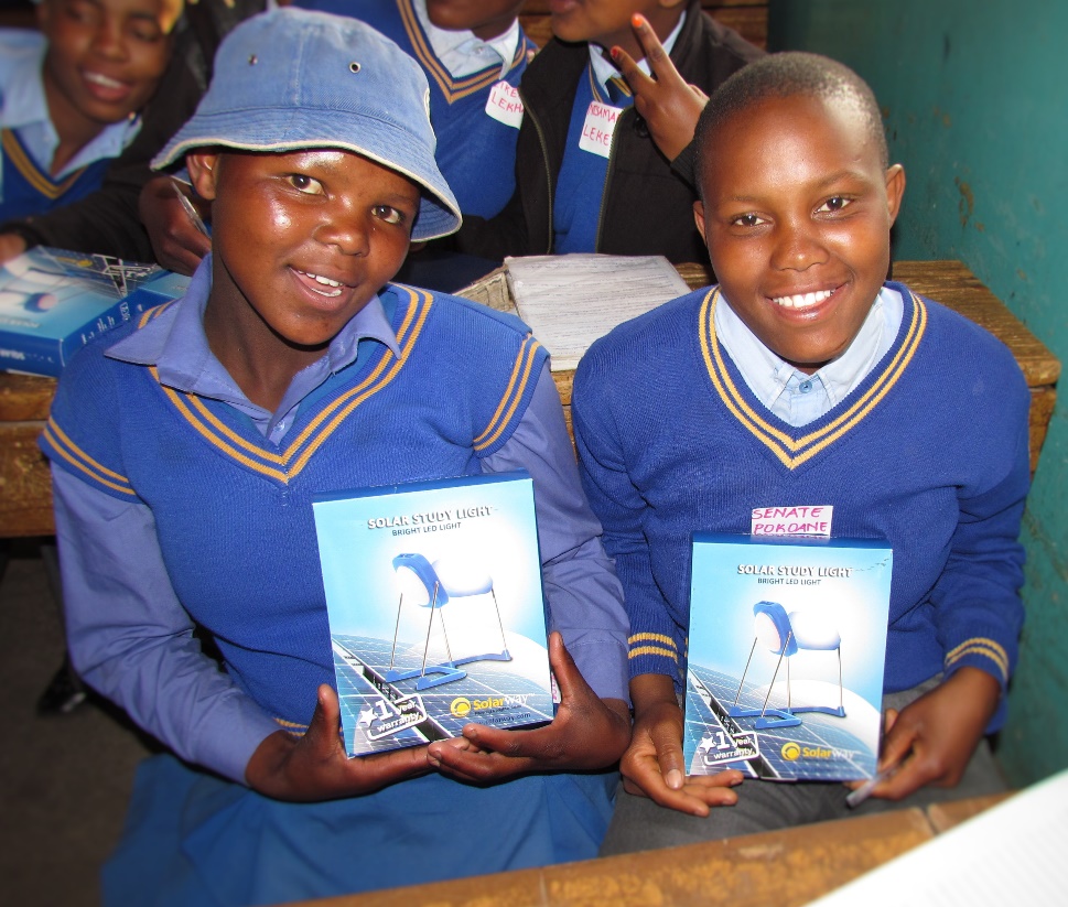 students smiling and holding solar lights